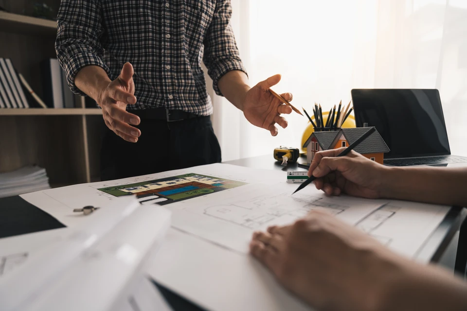 Architectes, ingénieurs, entrepreneurs discutent des plans de construction, des travaux de chantier, de la conception de la disposition