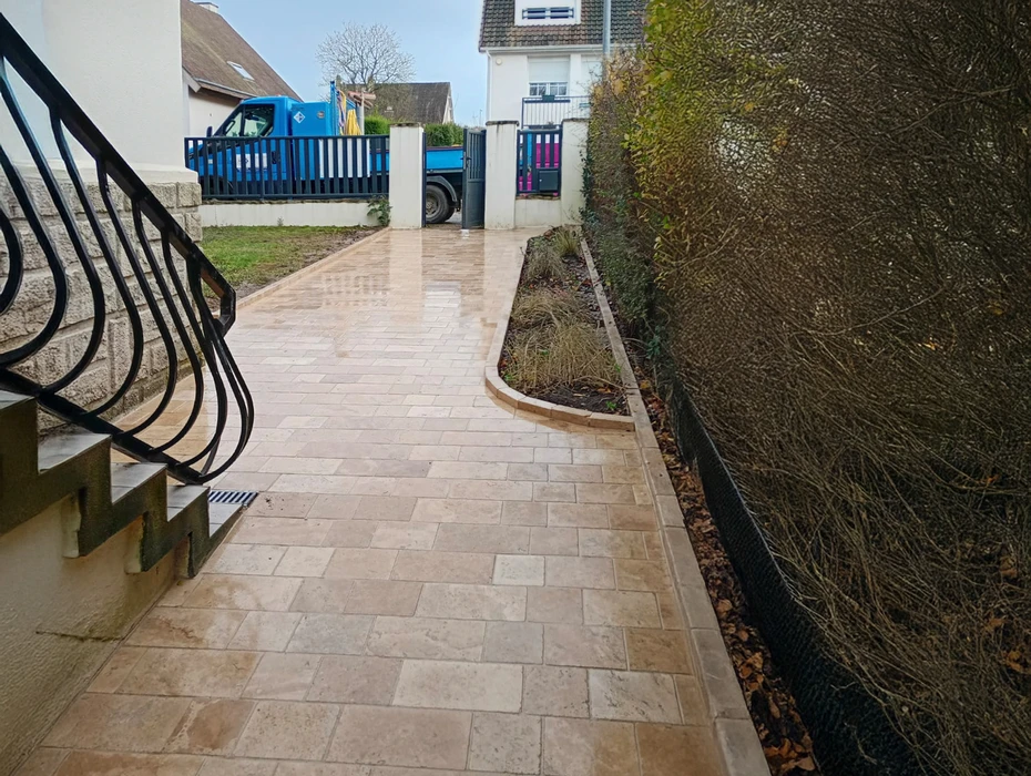 Chantier de construction extérieur avec dalle béton fraîchement coulée délimitée par coffrages bois et barrières de sécurité rouge et blanc