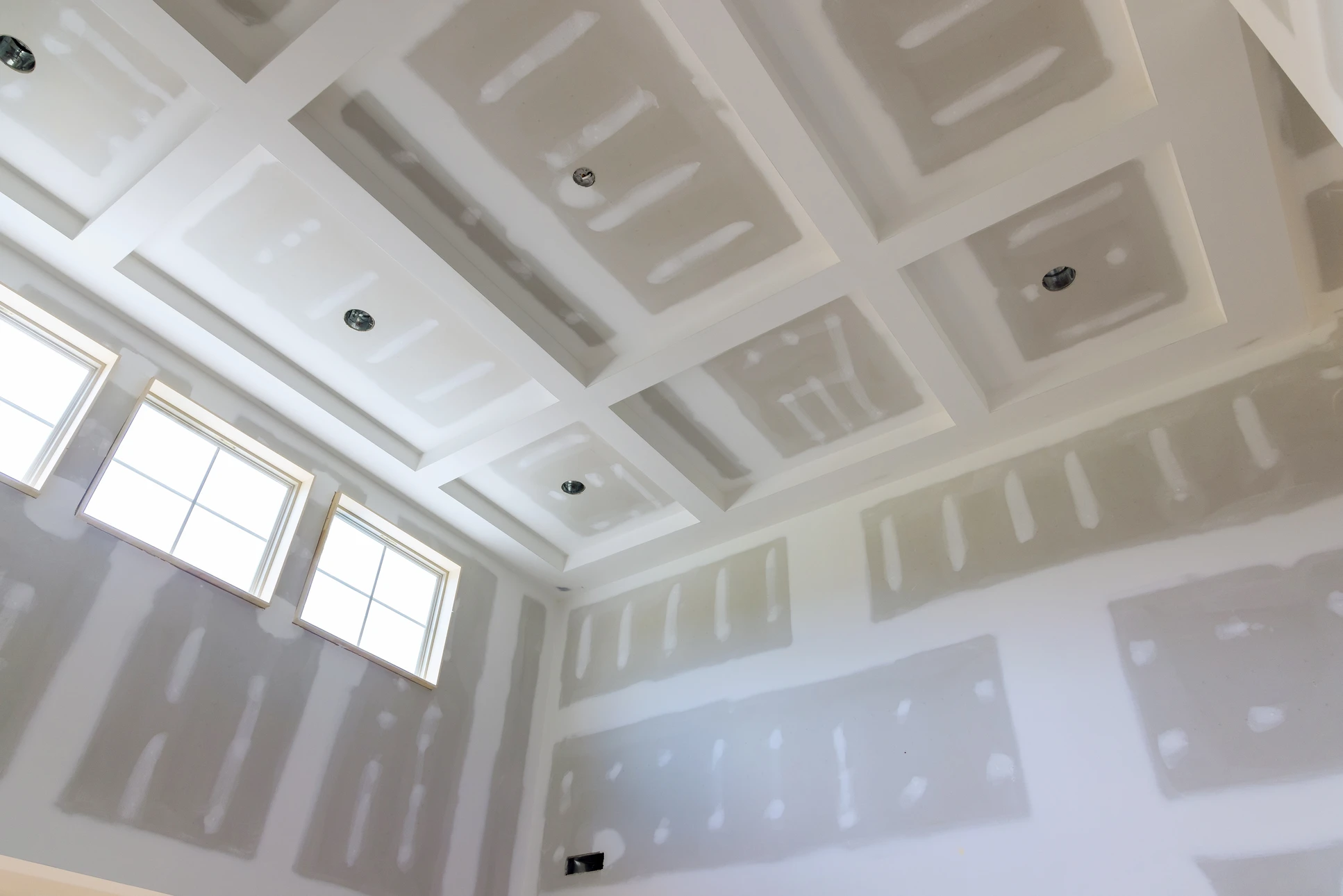 Intérieur commercial moderne avec plafond suspendu à caissons noirs et luminaires LED encastrés disposés en rangées régulières
